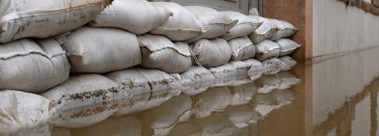 Hoog water; zandzakken voor de woning