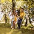 Een vader, moeder en 2 kinderen rennend door het bos